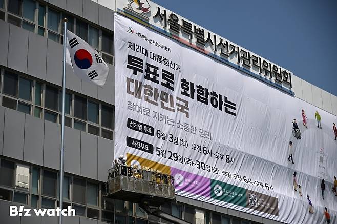 29일 오후 서울 종로구 창경궁로 서울시선거관리위원회 외벽에 관계자들이 제21대 대통령 선거 대형 홍보 현수막을 게시하고 있다./사진=이명근 기자 qwe123@