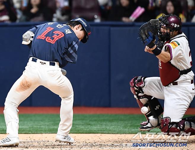 전민재의 헬멧에 맞은 공이 뚝 떨어지고 있다.