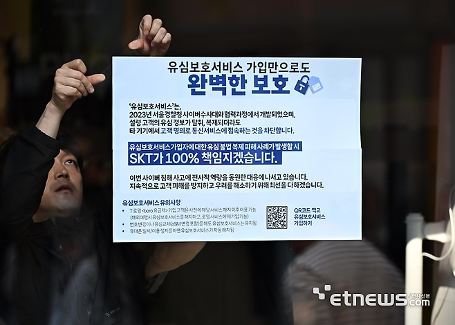28일 서울 중구 SKT PS&M 을지로점에서 관계자가 유심보호서비스 안내문을 부착하고 있다. SKT는 온라인 예약 시스템(care.tworld.co.kr) 을 통해 대기 시간 없이 유심을 교체할 수 있다고 밝혔다. 이동근 foto@etnews.com