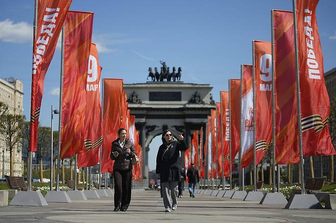 제2차 세계대전 중 소련이 나치 독일에 승리한 80주년 기념일을 앞둔 28일(현지시각) 러시아 수도 모스크바 개선문 옆 승리의 광장에 ‘5월9일’과 ‘승리’라고 적힌 깃발들이 휘날리는 가운데 사람들이 걷고 있다. AP 연합뉴스