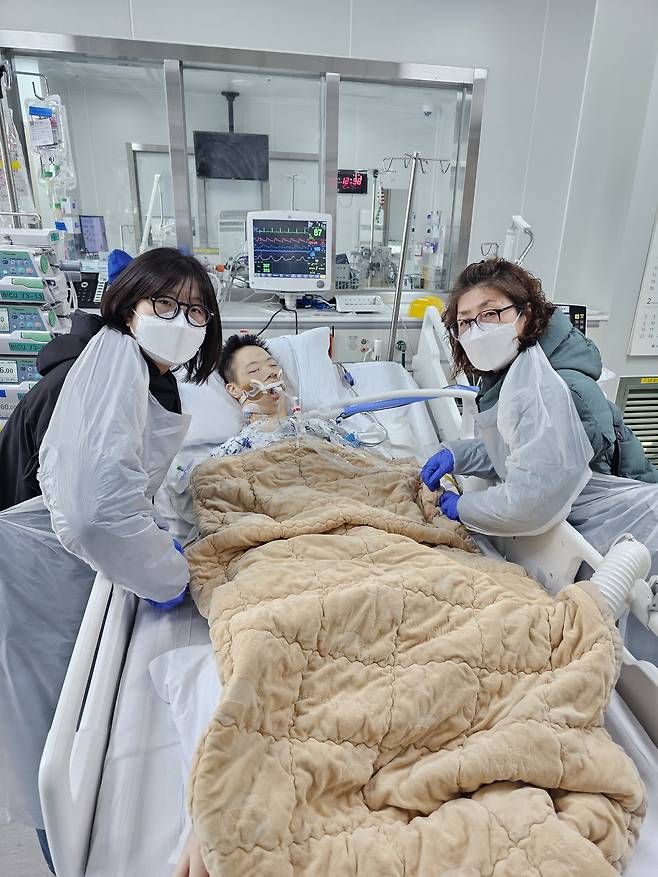 병실에 누워있는 김준혁씨(가운데)를 찾은 어머니 김미경씨(오른쪽)와 누나. 다운증후군을 가진 김준혁씨는 올해 1월 뇌사 장기기증으로 3명을 살리고 떠났다. 사진 김미경씨