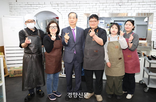 한덕수 대통령 권한대행이 지난 16일 결식 아동에게 무료 점심을 제공하는 울산 중구의 한 식당을 찾아 직원들을 격려한 뒤 기념사진을 찍고 있다. 대통령실사진기자단