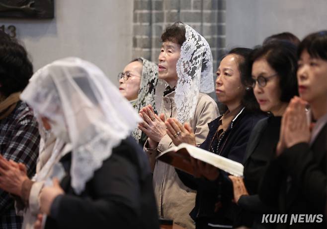 24일 오전 서울 중구 명동대성당에서 거행된 프란치스코 교황 추모 미사에서 참석자들이 기도를 하고 있다.