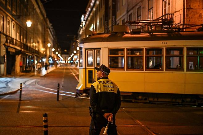 포르투갈의 수도  리스본에서 28일(현지시간) 대규모 정전 사태가 발생해 거리에서 운행 중단된 트램이 경찰이 지켜보는 가운데 견인되고 있다. [AFP]