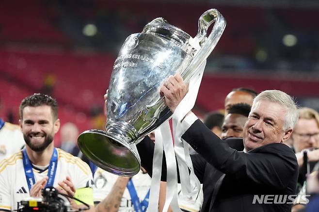 [런던=AP/뉴시스] 스페인 프로축구 프리메라리가 레알 마드리드의 카를로 안첼로티 감독이 1일(현지시각) 영국 런던의 웸블리 스타디움에서 도르트문트(독일)를 꺾고 '2023~2024시즌 유럽축구연맹(UEFA) 챔피언스리그(UCL)' 우승을 차지한 뒤 트로피를 들어올리고 있다. 2024.06.01.