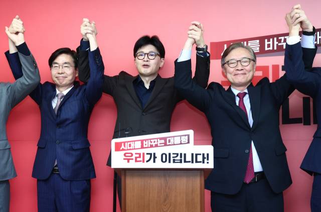 ▲국민의힘 한동훈 대선 경선 후보가 지난 18일 서울 여의도 선거 사무소에서 열린 캠프 인선 등 현안 관련 기자회견에서 최재형(오른쪽), 조경태 공동선대위원장과 손을 맞잡고 기념촬영을 하고 있다. ⓒ연합뉴스