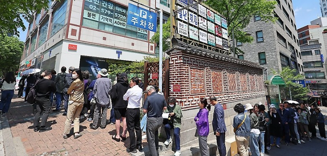 SK텔레콤이 유심 고객정보 해킹 사고로 관련 유심 무료 교체 서비스에 나선 28일 서울 시내 한 SK텔레콤 대리점 앞에 점심시간을 이용해 유심을 교체하려는 시민들이 줄지어 서 있다. 연합뉴스