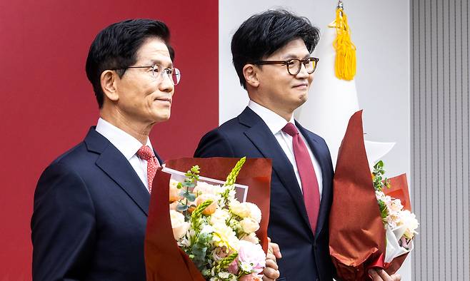 김문수 국민의힘 대선 경선 후보(왼쪽)와 한동훈 후보가 29일 서울 여의도 중앙당사에서 열린 제21대 대통령후보자 선출을 위한 3차 경선 진출자 발표에서 결과 발표 후 꽃다발을 들고 기념촬영을 하고 있다. 뉴시스