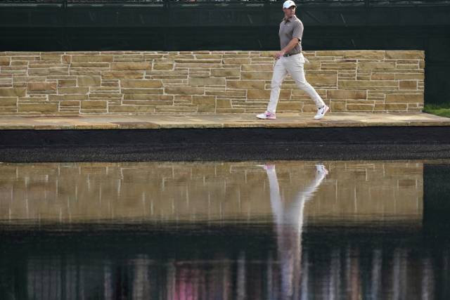 1라운드 15번 홀에서 세 번째 샷을 물에 빠뜨리고 드롭존으로 향하는 매킬로이. AP연합뉴스