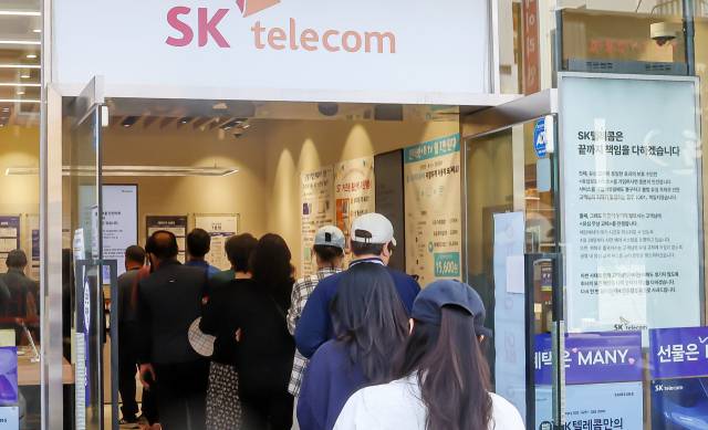 SK텔레콤이 유심 고객정보 해킹 사고로 관련 유심 무료 교체 서비스에 나선 지난 28일 부산 시내 한 SK텔레콤 대리점 앞에 유심을 교체하려는 시민들이 줄지어 서 있다. 김종진 기자 kjj1761@