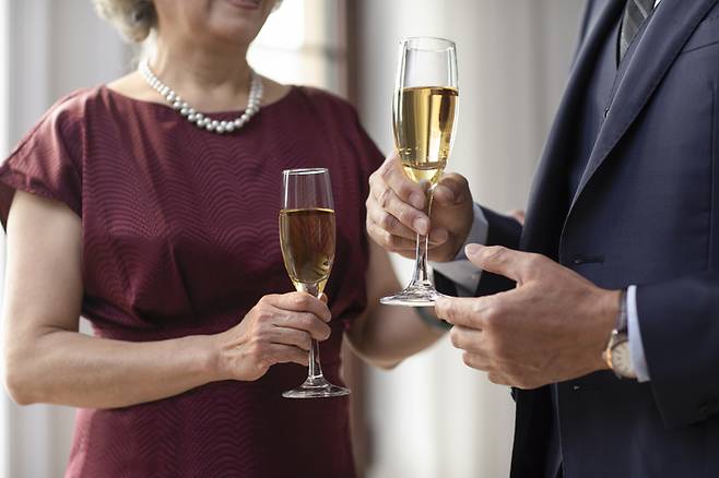 나이든 남녀가 샴페인을 마시고 있다. 샴페인과 화이트와인을 즐기는 사람은 심장마비를 일으킬 위험이 낮다는 연구 결과가 나왔다. 반면 술은 한 잔도 해롭다는 게 세계보건기구(WHO)의 공식 입장이다.[사진=게티이미지뱅크]