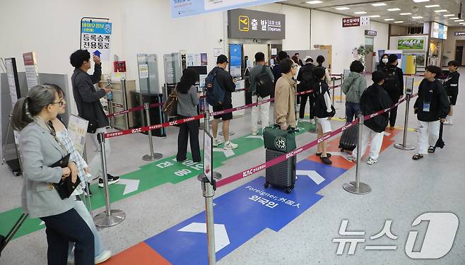 긴 황금연휴를 앞둔 29일 광주공항 출발 탑승구 앞에서 시민들이 제주행 비행기에 탑승하기 위해 채비하고 있다. 2025.4.29/뉴스1 ⓒ News1 이수민 기자