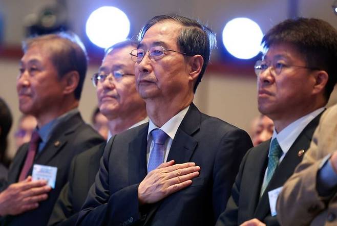 한덕수 대통령 권한대행 국무총리가 29일 오후 서울 강남구 건설회관에서 열린 '해외건설 1조 달러 수주 및 60주년 기념식'에 참석해 국기에 경례하고 있다. 연합뉴스