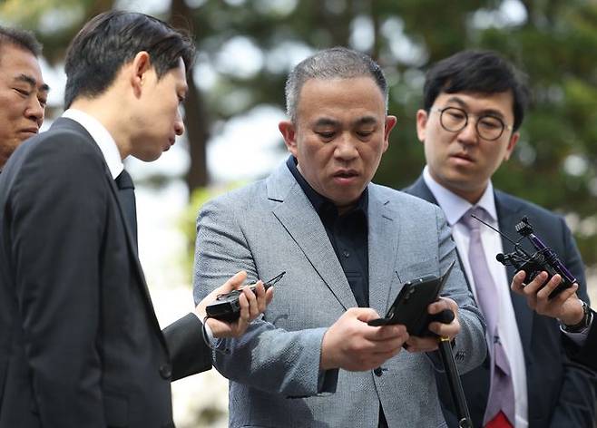 '정치브로커' 명태균씨가 30일 윤석열 전 대통령 부부와 여권 정치인 다수가 연루된 공천 개입·여론조사 의혹 관련 조사를 받기 위해 서초구 서울고등검찰청으로 향하며 취재진의 질문에 답변하며 휴대전화를 들어 보이고 있다. ⓒ연합뉴스