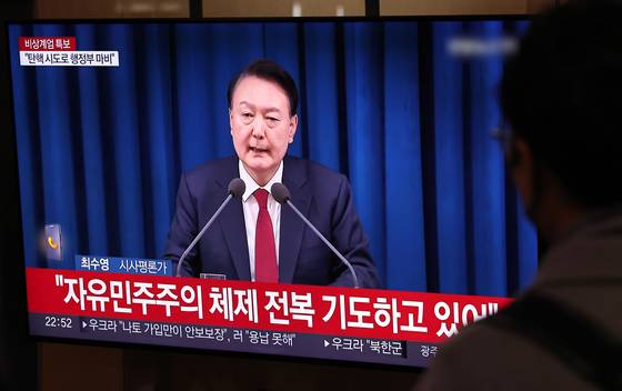 윤석열 전 대통령이 대국민담화를 열고 비상계엄을 선포한 지난헤 12월 3일 밤 서울역 대합실에서 시민들이 관련 뉴스를 시청하고 있다. 뉴스1