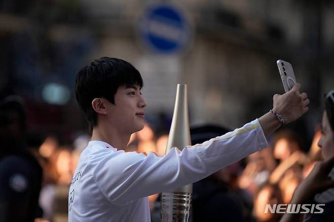 그룹 방탄소년단(BTS) 멤버 진이 2024년 7월 14일(현지시각) 프랑스 파리 루브르 박물관 인근에서 2024 파리 하계 올림픽 성화 봉송을 하기 앞서 셀카를 찍고 있다. [AP·뉴시스]