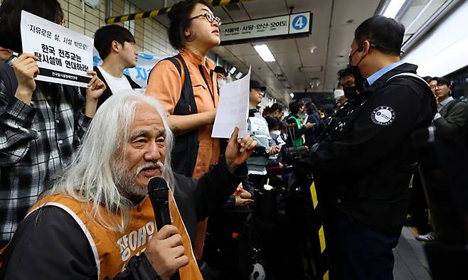 전국장애인차별철폐연대(전장연)의 출근길 지하철 탑승 시위가 1년여 만에 재개된 지난 21일 서울 지하철 4호선 혜화역에서 박경석 전장연 대표를 비롯한 회원들이 시위를 하고 있다. 뉴시스