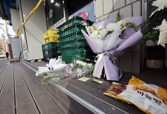 2월 14일 오후 경기 시흥시의 한 편의점 앞에 추모의 글귀가 적힌 쪽지와 국화 꽃다발, 간식 등이 놓여있다. 연합뉴스