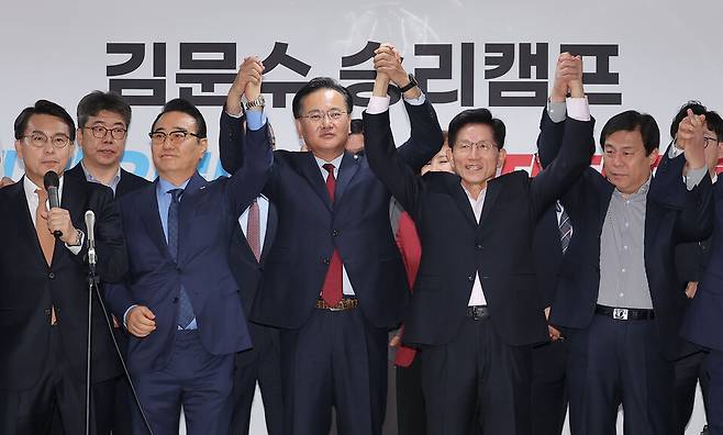 김문수 국민의힘 제21대 대통령 선거 경선 후보가 30일 서울 여의도 대하빌딩 후보 캠프 사무실에서 지지 선언을 위해 찾은 홍준표 전 대구시장 경선 캠프 소속 의원들과 함께 손을 맞잡고 있다. ⓒ연합뉴스