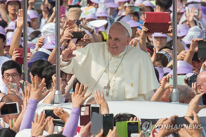 한국 천주교 신자들에게 인사하는 교황 (서울=연합뉴스) 사진은 지난 2014년 8월 16일 광화문광장에서 열린 시복식 미사에 앞서 차량에서 한국 신자들에게 인사하는 교황 모습. 2025.4.21 [연합뉴스 자료사진] photo@yna.co.kr