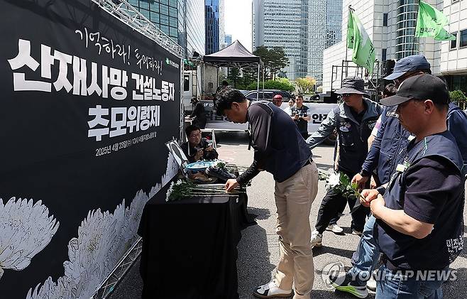 산재사망 건설노동자들을 위한 헌화 (서울=연합뉴스) 서명곤 기자 = 23일 서울 중구 서울고용노동청 앞에서 열린 산재사망 건설노동자 추모 위령제에서 참가자들이 헌화하고 있다. 2025.4.23 seephoto@yna.co.kr