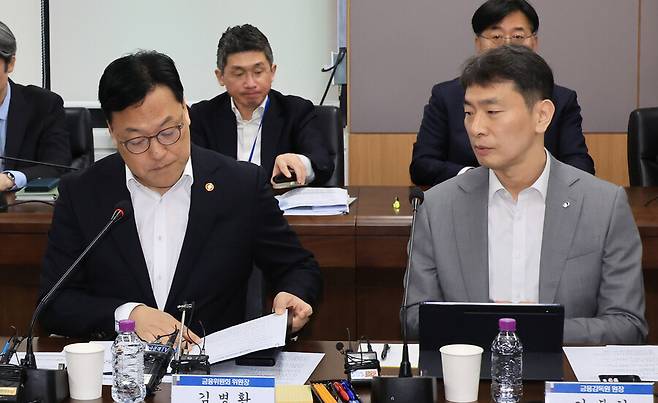 김병환 금융위원회 위원장이 지난달 7일 서울 종로구 정부서울청사에서 열린 금융 상황 점검 회의에서 이복현 금융감독원장과 대화하고 있다. 연합뉴스