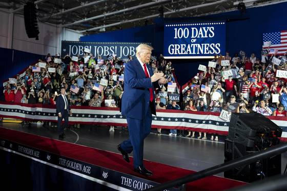 도널드 트럼프 미국 대통령이 29일(현지시간) 미시간주 워런에 위치한 매콤 카운티 커뮤니티 칼리지 스포츠 엑스포센터에서 열린 대통령 취임 100일 기념식 도중 지지자들의 환호 속에 무대에 오르고 있다. [AP=연합뉴스]