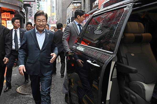 Democratic Party leader Lee Jae-myung walks toward his car after meeting with workers in Jongno District, central Seoul, on May 1. [JOONGANG ILBO]