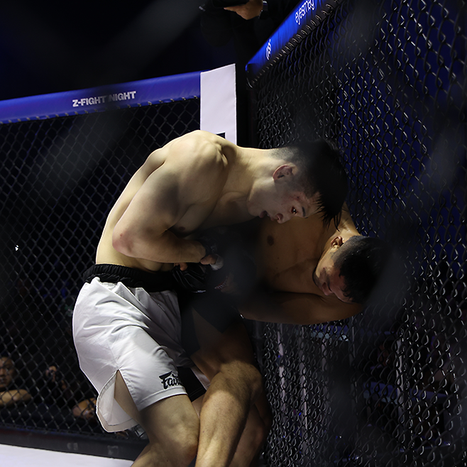 장윤성이 ZFN 2 메인카드 제4경기 클린치 공방에서 사토 다카시를 케이지로 밀어붙이고 있다. 사진=MCP ECC