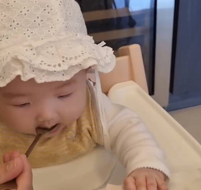 서우는 레이스 모자를 눌러쓰고 통통한 뺨을 자랑하며 이유식을 받아먹고 있는 모습이다. 사진=이정현 SNS