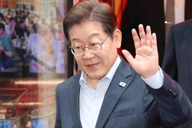 더불어민주당 이재명 대선 후보가 1일 서울 종로구의 한 포차 식당에서 '당신의 하루를 만드는, 보이지 않는 영웅들'이란 주제로 열린 배달 라이더, 택배 기사 등 비(非)전형 노동자들과의 간담회를 마친 뒤 나서며 손인사를 하고 있다. 연합뉴스