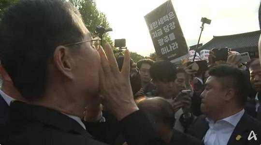 한덕수 전 대통령 권한대행이 2일 광주 북구 운정동 국립 5·18 민주묘지를 참배하려다 일부 시민단체의 반발에 가로막히자 "서로 사랑해야 한다. 바뀌어야 한다"고 외치고 있는 모습.(사진/채널A방송 캡쳐)