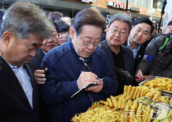 '골목골목 경청투어 : 접경벨트편'에 나선 이재명 더불어민주당 대통령 후보가 2일 오전 강원 철원군 동송전통시장에서 청년 상인의 발언을 메모 하고 있다. (공동취재) 2025.5.2/뉴스1 ⓒ News1 이재명 기자