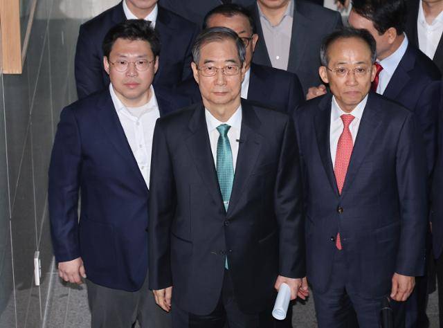 한덕수(가운데) 전 대통령 권한대행 국무총리가 2일 대선 출마 선언을 위해 추경호(오른쪽) 국민의힘 의원 등과 함께 서울 여의도 국회 소통관으로 이동하고 있다. 연합뉴스