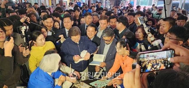 ▲ 이재명 후보가 거진전통시장에서 자서전을 가져온 주민들에게 사인 서비스를 해주고 있다.