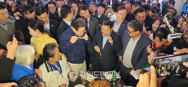 ▲ 이재명 후보가 거진전통시장에서 닭강정을 맛보고 있다.