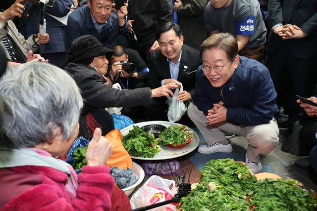 ▲ 더불어민주당 이재명 대선 후보가 ‘골목골목 경청투어’ 접경지역 방문 이틀째인 2일 강원도 인제군 원통전통시장에서 엄나무순을 사며 어르신과 대화하고 있다. 연합뉴스