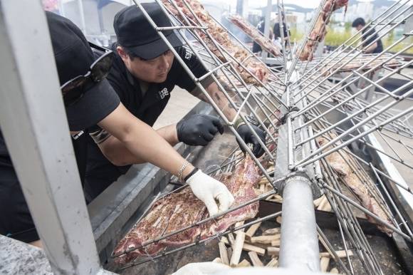 지난해 10월10일 서울 송파구 가락몰 3층 하늘공원에서 서울시농수산식품공사 주최로 ‘가락 옥토버페스트’가 열린 가운데 관계자들이 바비큐를 굽고 있다. 서울시농수산식품공사 제공