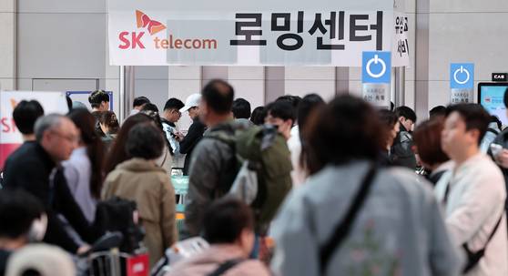 Travelers line up at Incheon International Airport on May 2 to replace their subscriber identity module (SIM) cards at SK Telecom Roaming Center before departure. [NEWS1]