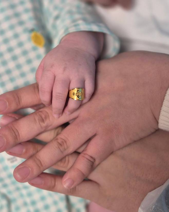 백일을 기념해 돌반지를 낀 솔이의 손이 솔이 엄마 아빠의 손에 포개진 모습. 안지은씨 제공