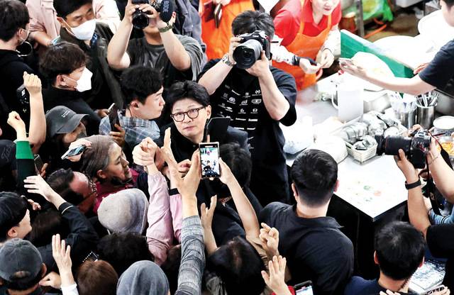 한동훈 국민의힘 대선 경선 후보가 1일 보수 핵심인 대구 중구 서문시장에서 지지자들에게 둘러싸인 채 인사하고 있다. 한 후보는 TK 지역 방문을 통해 ‘비토론’을 극복하는 데 주력했다. 뉴시스