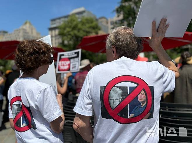 [워싱턴=뉴시스]이윤희 특파원 =국제 노동절인 1일(현지 시간) 미국 전역에서는 도널드 트럼프 행정부에 반대하는 집회가 동시다발적으로 벌어진 가운데, 미국 워싱턴DC 백악관 인근 프랭클린 공원에서 열린 '메이 데이' 집회에 트럼프 대통령과 일론 머스크를 비판하는 티셔츠를 입고 참석한 참가자들. 2025.05.02.