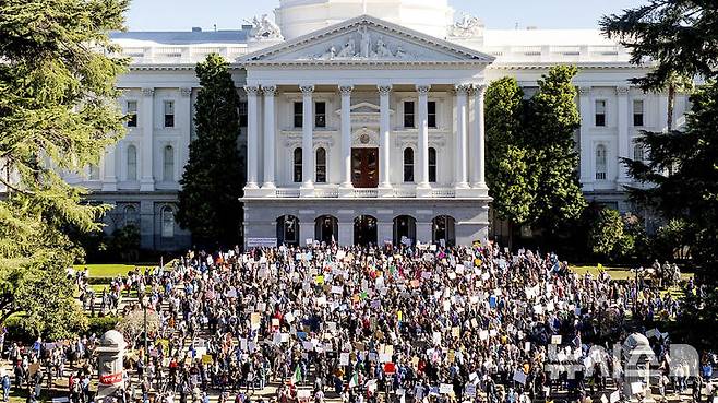 [새크라멘토=AP/뉴시스]   미 캘리포니아주 새크라멘토의 캘리포니아주 의사당 앞에서 지난 2월 5일 수많은 시위대가 도널드 트럼프 대통령의 강력한 이민 단속과 추방 정책에 항의하는 시위를 벌이고 있다.  캘리포니아주는 미국에서 가장 인구가 많은 주로 최근 2년간 더 늘어났다. 2025.05.02.