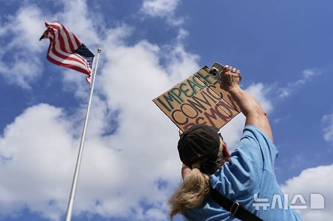 [휴스턴=AP/뉴시스] 1일(현지 시간) 미 텍사스주 휴스턴 시청 앞에서 열린 노동절 시위에 참여한 한 시민이 반트럼프 팻말을 들고 있다. 2025.05.02.