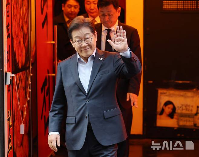 [서울=뉴시스] 조성우 기자 = 이재명 더불어민주당 대선후보가 1일 오후 서울 종로구의 한 포장마차에서 열린 비전형 노동자 간담회를 마치고 나오며 손을 들어 보이고 있다. 대법원 전원합의체는 이날 이 후보에게 무죄를 선고한 원심 판결을 파기하고 사건을 서울고법으로 돌려보냈다. (공동취재) 2025.05.01. photo@newsis.com