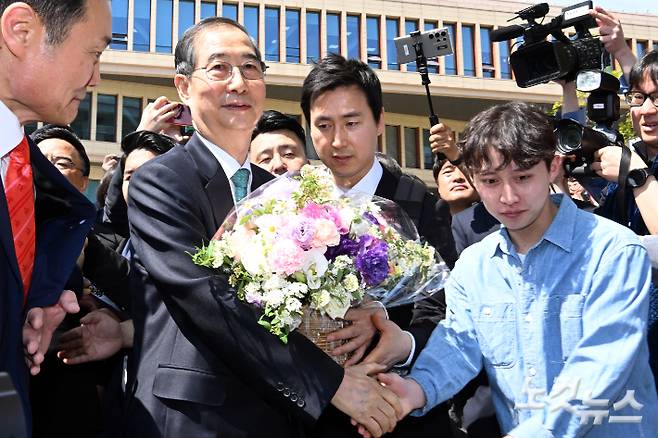 한덕수 전 국무총리가 2일 서울 여의도 국회 소통관에서 제21대 대통령 선거 출마선언 기자회견을 마치고 이동하며 지지자로부터 꽃다발을 전달받고 있다. 윤창원 기자
