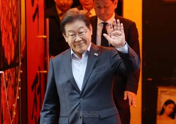 이재명 더불어민주당 대선 후보가 지난 1일 서울 종로구의 한 포차 식당에서 ‘당신의 하루를 만드는, 보이지 않는 영웅들’이란 주제로 열린 배달 라이더, 택배 기사 등 비전형 노동자들과의 간담회를 마친 뒤 나서며 손인사를 하고 있다. 연합뉴스