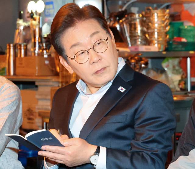 이재명 더불어민주당 대선 후보가 1일 서울 종로구의 한 포차 식당에서 '당신의 하루를 만드는, 보이지 않는 영웅들'이란 주제로 배달 라이더, 택배 기사 등 비(非)전형 노동자들과 간담회를 하고 있다. 연합뉴스