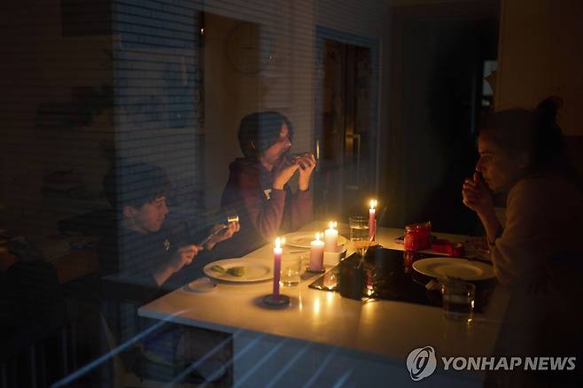 스페인 대정전 (AP=연합뉴스) 지난달 28일(현지시간) 스페인 대정전으로 바르셀로나의 한 가족이 촛불을 켠 채 스낵을 먹는 모습. 2025.5.2.