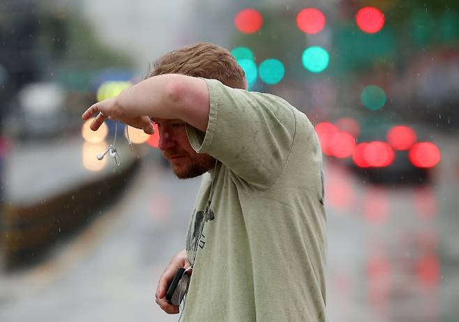 지난 1일 서울 종로구 세종로사거리에서 우산을 준비하지 못한 외국인이 비를 맞으며 횡단보도 신호를 기다리고 있다. (사진=연합뉴스)